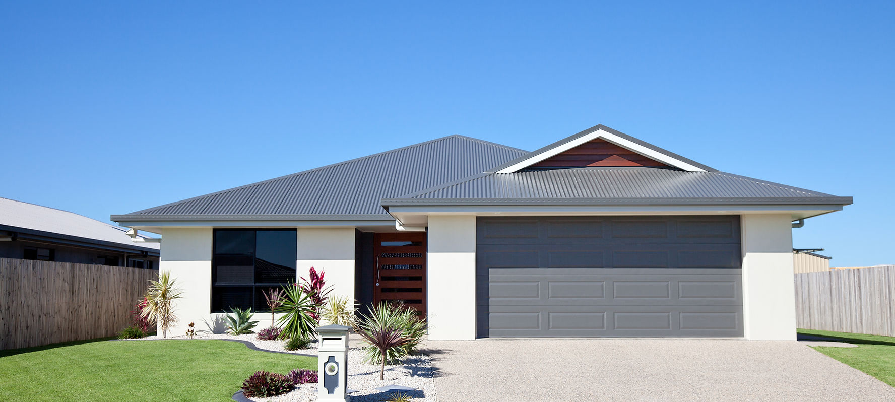 Newly painted modern house exterior with gray roof and garage door